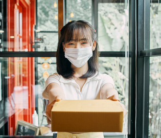 female delivering a package and wearing a mask